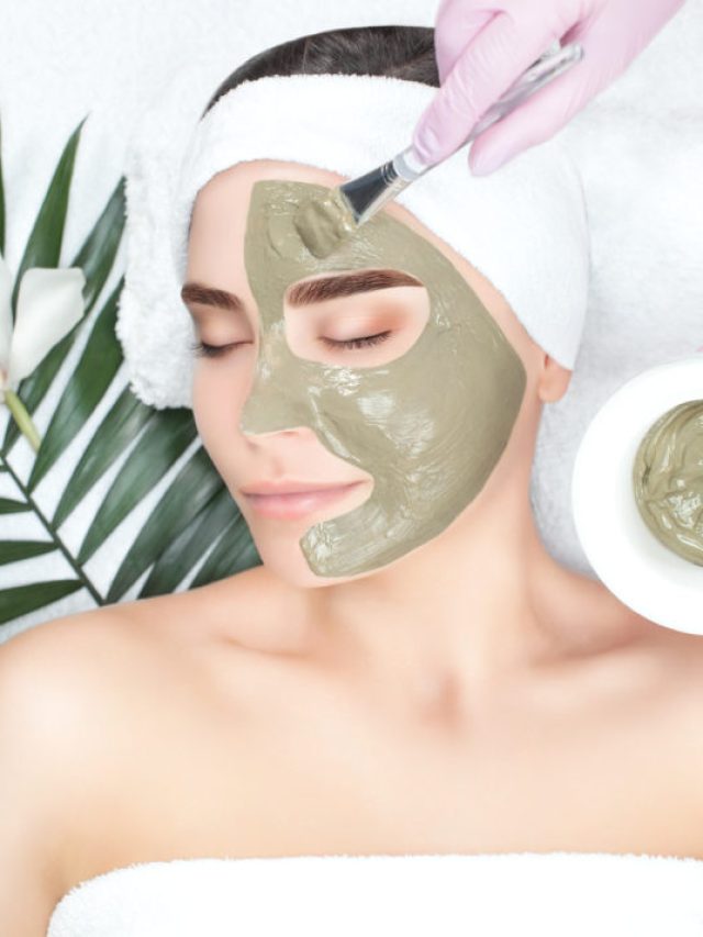 The procedure for applying a mask from clay to the face of a beautiful woman. Spa treatments and care of the face in the beauty salon.