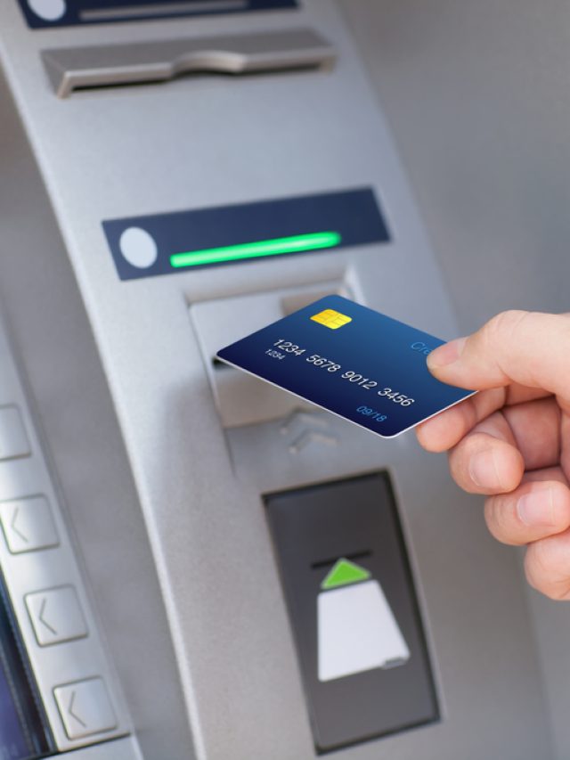 man puts credit card into ATM
