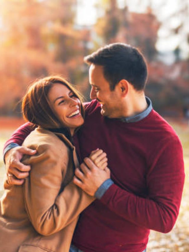Couple in love hugging and enjoying at public park in autumn