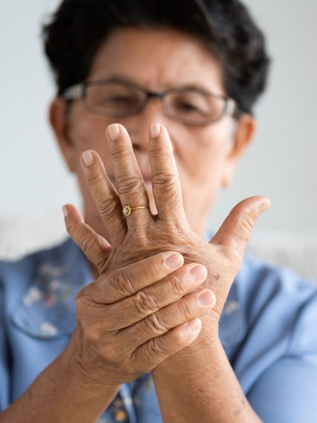 Asian old woman sitting on sofa and having hand pain, hand injury at home. Senior healthcare concept.