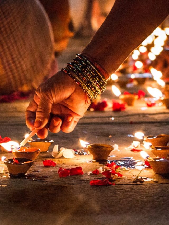 Close-Up Of Hand Holding Illuminated Candles