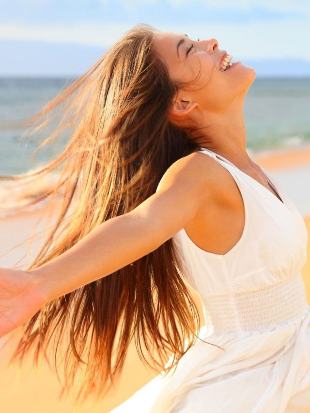 a-stress-free-woman-on-the-beach-with-her-arms-open-wide