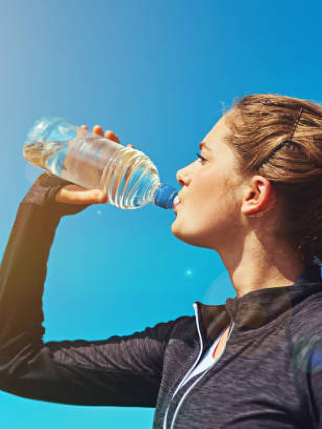 Shot of a sporty young woman drinking water outdoors