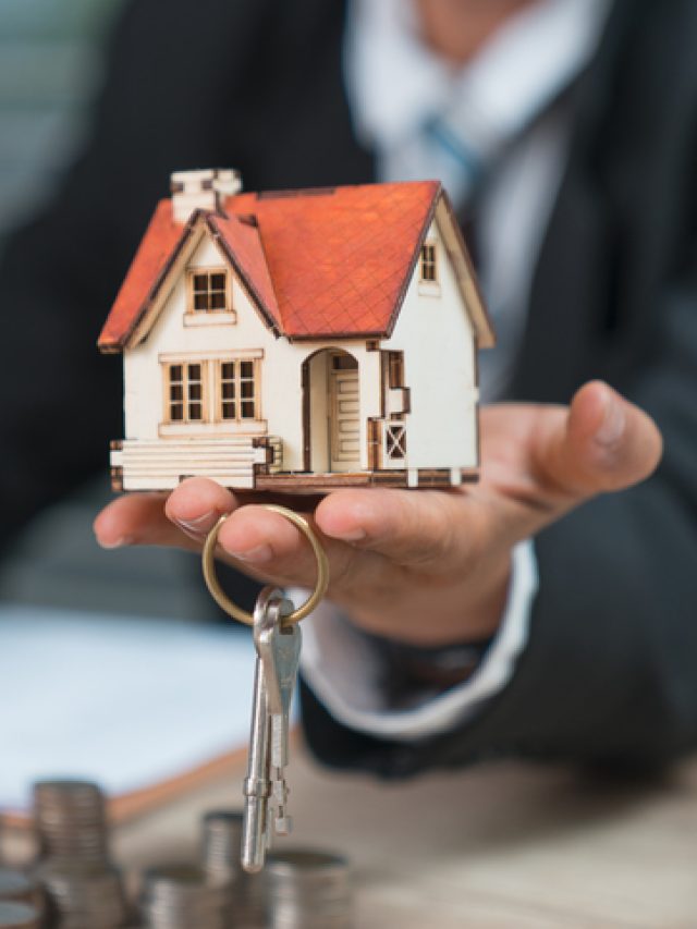 House key in home insurance broker agent's hand protection or in salesman person giving to buyer customer